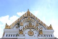 White cement gable and gold color Buddhist church.