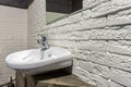 White ceramic bathroom sink with mirror on loft brick wall background Royalty Free Stock Photo