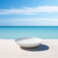 White ceramic bowl on the beach with blue sea and sky background.