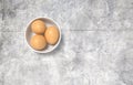 White ceramic bowl ful of eggs. Placed on concrete table. Royalty Free Stock Photo