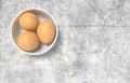 White ceramic bowl ful of eggs. Placed on concrete table. Royalty Free Stock Photo