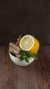 White ceramic bowl with natural healthy flavours for herbal tea and hot dinks half of lemon, fresh mint and ginger on Royalty Free Stock Photo