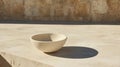 A white ceramic bowl sits on a light beige stone ledge. Royalty Free Stock Photo