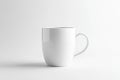 A white ceramic coffee mug featuring a handle is placed on a white surface Royalty Free Stock Photo