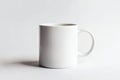 A white ceramic coffee mug featuring a handle is placed on a white surface Royalty Free Stock Photo