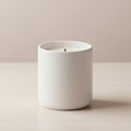 White ceramic container holding a single lit candle sits on a light wooden surface. The Royalty Free Stock Photo