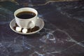 White ceramic cup with coffee on a saucer, decorated with sugar cubes and coffee beans Royalty Free Stock Photo