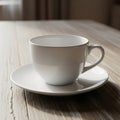 A white ceramic cup with a handle sits on a matching saucer on a wooden table. The Royalty Free Stock Photo