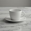 White ceramic cup and saucer on a gray and white marble surface. The cup is round Royalty Free Stock Photo