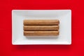 White ceramic dish with luxury Cuban cigars on over red background Royalty Free Stock Photo