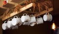 White ceramic glasses hung from the ceiling in a coffee shop
