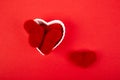 White ceramic hearts with red plush hearts on red background. Flat lay composition. Romantic, St Valentines Day concept