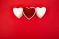 White ceramic hearts with red plush hearts on red background. Flat lay composition. Romantic, St Valentines Day concept.