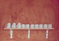 White ceramic kitchenware on the wooden shelf with grunge cement background,retro filter effect Royalty Free Stock Photo