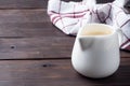 White ceramic milk jug with fresh milk. Dark wooden rustic table. Copy space. Royalty Free Stock Photo