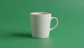 White ceramic mug with a curved handle sits on a smooth green backgroun Royalty Free Stock Photo