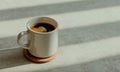 White ceramic mug filled with dark espresso on a textured concrete surface with natural light Royalty Free Stock Photo