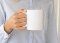 White ceramic mug mockup. Girl Holding a Cup of tea. Space for your text branding