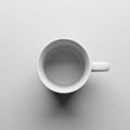 A white ceramic mug is positioned centrally on a flat light gray surface Royalty Free Stock Photo