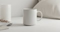 A white ceramic mug with a smooth finish is placed on a light-colored surface. It Royalty Free Stock Photo