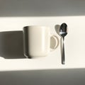 Mug has a simple handle, and both objects cast long shadows due to the Royalty Free Stock Photo