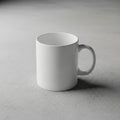 White ceramic mug on a textured gray surface. Simple cylindrical design with a single Royalty Free Stock Photo