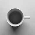 A white ceramic mug is viewed from above on a plain gray surface Royalty Free Stock Photo
