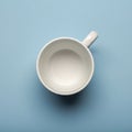 White ceramic mug viewed from above, resting on a solid pastel blue surface. The mug Royalty Free Stock Photo