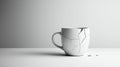 White ceramic mug with visible cracks sits on a smooth, light gray surface