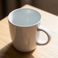 White ceramic mug on a wooden surface with sunlight casting shadows. The mug ha Royalty Free Stock Photo