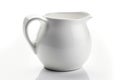 A white ceramic pitcher with a handle and a spout, round and smooth, on a plain white background Royalty Free Stock Photo