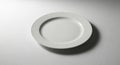 White ceramic plate centered on a textured light gray surface. The plate features a Royalty Free Stock Photo