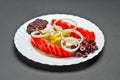 White ceramic plate with marinated olives, tomatoes, pepper, onion, feta cheese, olive oil and spice mix Royalty Free Stock Photo