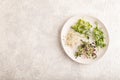 White ceramic plate with microgreen sprouts of green pea, sunflower, alfalfa, radish on gray. Top view