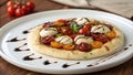On a white ceramic plate a small pizza features a delicate crisp crust. The pizza is generously topped with a colorful Royalty Free Stock Photo