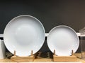 White ceramic plates on shelf in a store. Designer ceramic plates with a pattern. Table setting, tableware and eating concept Royalty Free Stock Photo