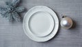 White Plates And Silver Christmas Ornament With Pine Branches On Gray Tablecloth. Minimal Holiday Table Setting Royalty Free Stock Photo