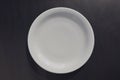 White ceramic round plate on black background