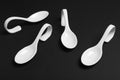 White ceramic serving spoons on background