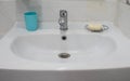 White ceramic sink in bathroom with plastic glass for brush and soap for hand cleaning Royalty Free Stock Photo