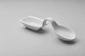 A white ceramic spoon rest sits on a light gray surface Royalty Free Stock Photo