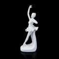 White ceramic statuette of a ballerina on a black background. antique figurine of a ballerin