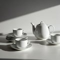 White ceramic tea set with a teapot and multiple cups on saucers, arranged on a white Royalty Free Stock Photo