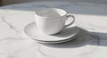 White ceramic teacup and saucer set on a polished marble surface. The cup is simple Royalty Free Stock Photo