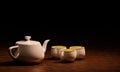 White ceramic teacup and white teapot on a wooden surface. Side view of drink sets 3D Rendering