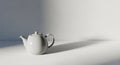 A white ceramic teapot with a classic design sits on a flat surface. It features a rounded body, a Royalty Free Stock Photo
