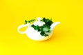 White ceramic teapot with ecological plants on yellow background. Zero waste concept. Close-up Royalty Free Stock Photo