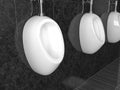 White ceramic urinals. On black tiles background. Public toilet