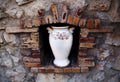 White Ceramic Vase With Painted Flowers In Antique Wall Niche