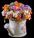 White ceramic watercan, sprinkler, with vivid colored flowers, orange tagetes, purple wild flowers, close up